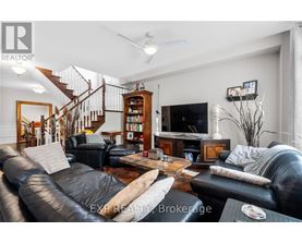 A living room with a staircase and a bookcase.