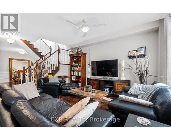 A living room with a staircase and a bookcase.