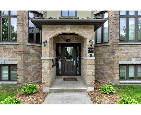 A house numbered 129 has a black door and a stone archway.