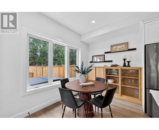 A dining room with a table set for two and a view of a backyard.
