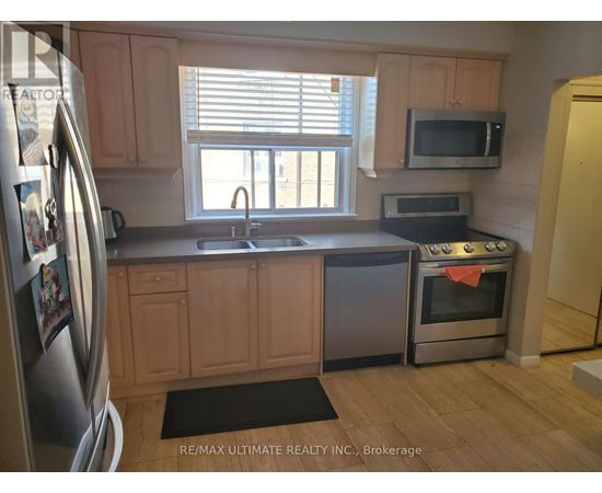 A kitchen with wooden cabinets and a stainless steel refrigerator.