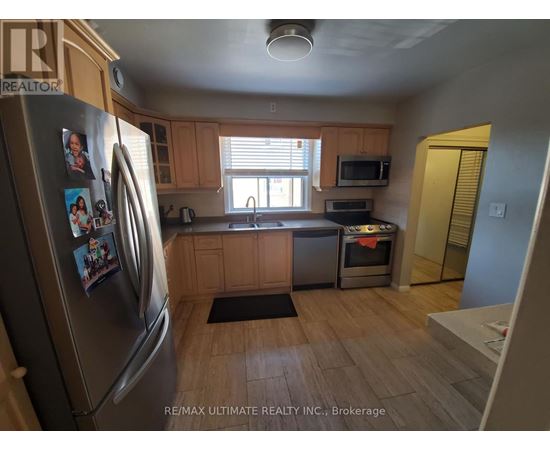 A kitchen with a refrigerator on the left and a microwave on the counter.