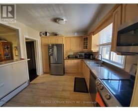 A kitchen with a refrigerator, stove, and sink.