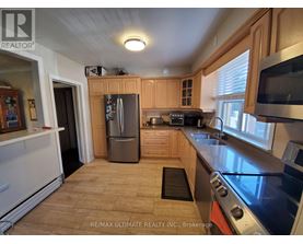 A kitchen with wooden cabinets and a stainless steel oven.