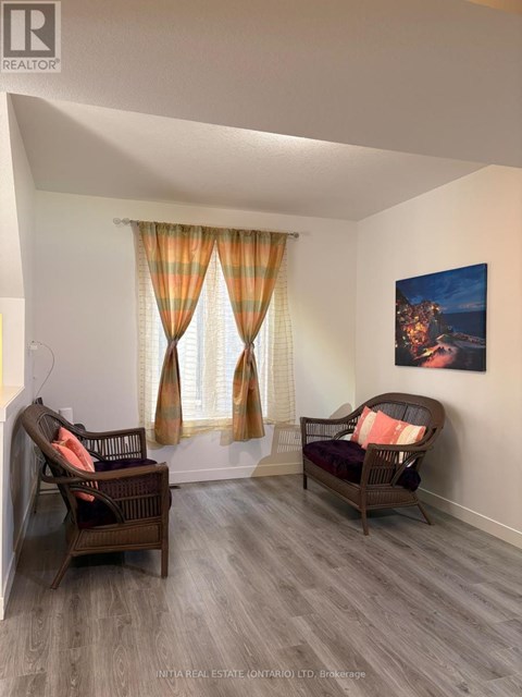 A living room with two chairs and a painting on the wall.