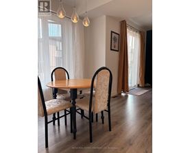A dining room with a table and chairs.
