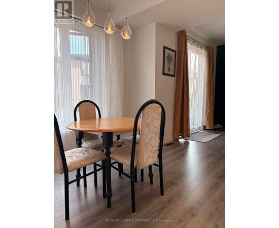 A dining room with a table and chairs.