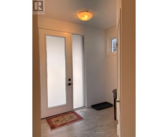 A hallway with a rug on the floor and a door on the left.