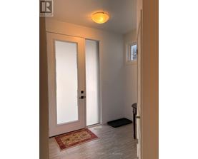 A hallway with a rug and a door.