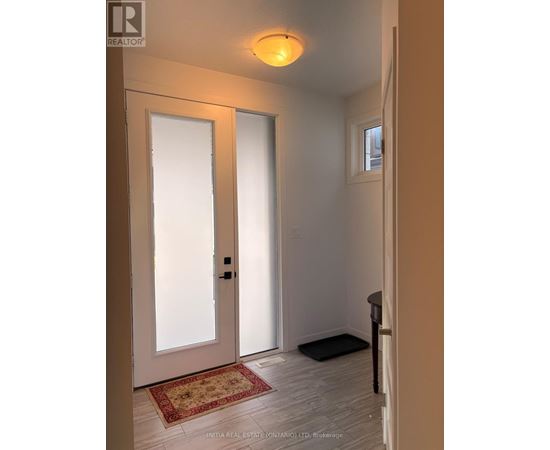 A hallway with a rug and a door.