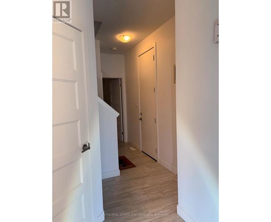 A hallway with a white door and a light on the wall.