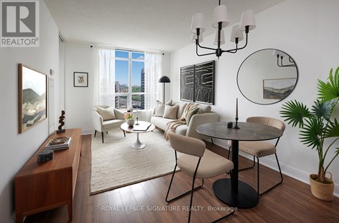 A living room with a round table and chairs, a rug, and a large window with a view of the city.