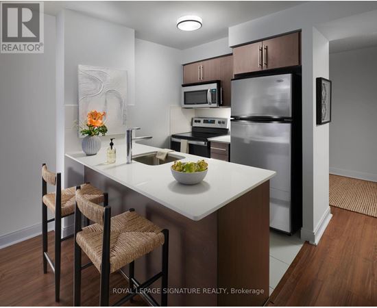 A kitchen with a white countertop and brown chairs.