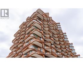 A tall building with a curved design and balconies on each floor.