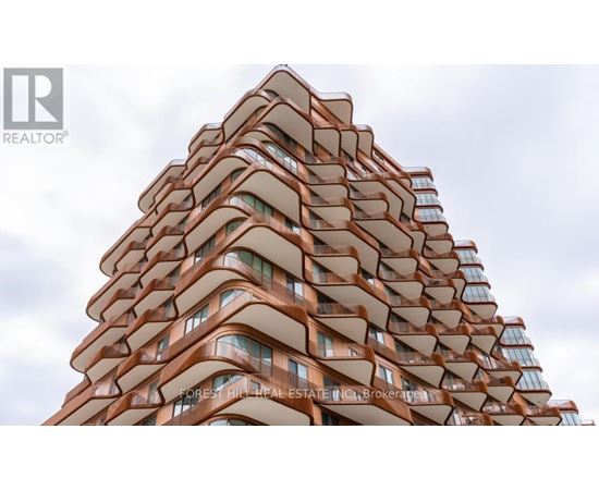 A tall building with a curved design and balconies on each floor.