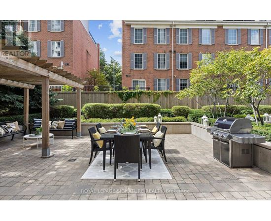 A patio with a table and chairs is surrounded by a brick building.