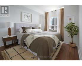 A bedroom with a large bed and a potted plant.