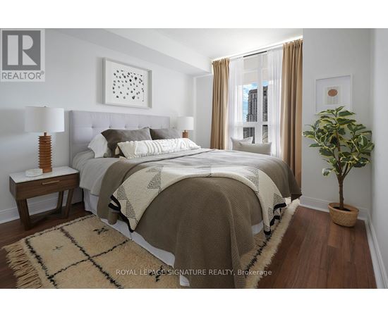 A bedroom with a large bed and a potted plant.