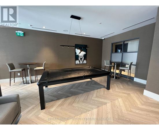 A room with a pool table and chairs.