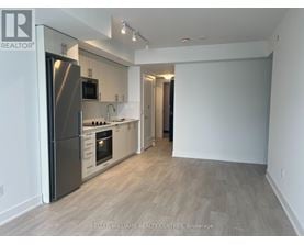 A spacious kitchen with a refrigerator, microwave, oven, and sink.