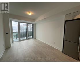 A spacious room with a refrigerator on the right side.