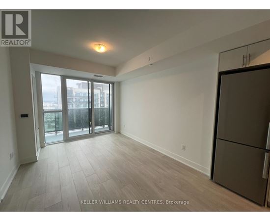 A spacious room with a refrigerator on the right side.