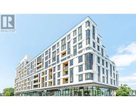 A modern multi-story building with a glass entrance and balconies.