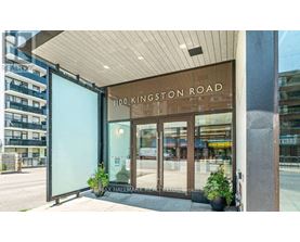 The entrance to a building with a glass door and a sign that reads "1100 Kingston Road".