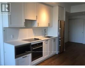 A kitchen with white cabinets and a stainless steel refrigerator.