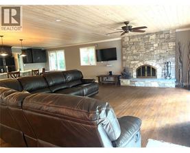 A living room with a stone fireplace and a stone wall.