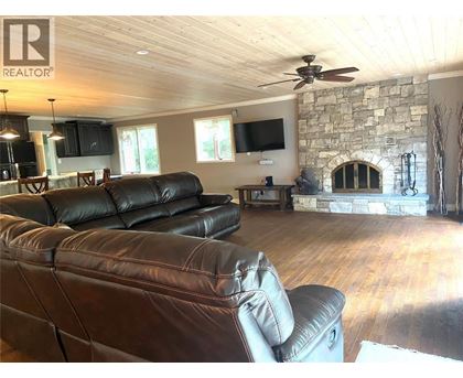 A living room with a stone fireplace and a stone wall.
