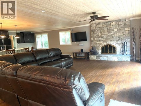 A living room with a stone fireplace and a stone wall.