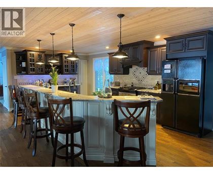 A kitchen with a bar area and wooden floors.