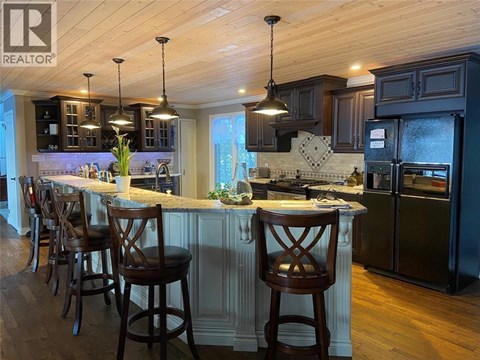 A kitchen with a bar area and wooden floors.