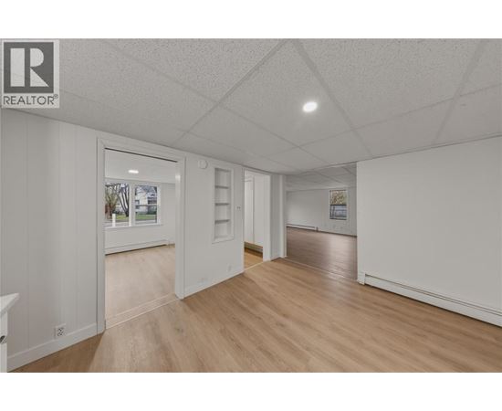 A spacious room with wooden floors and white walls.