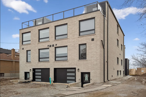 A modern building with a balcony on the top floor.
