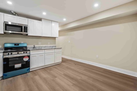 A kitchen with a blue stove and white cabinets.