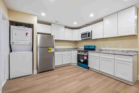 A kitchen with white cabinets and a stainless steel refrigerator.