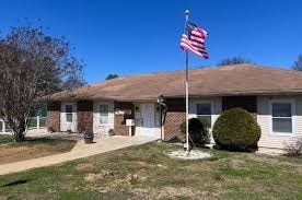A house with a flag on the front lawn.