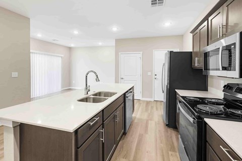 A modern kitchen with dark wood cabinets and white countertops.