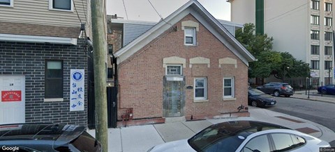 A small brick building with a white door and windows.