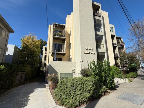 A tall beige building with balconies and a number 491 on the front.
