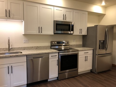 A kitchen with white cabinets and stainless steel appliances.