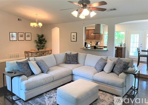 A living room with a white couch and a ceiling fan.