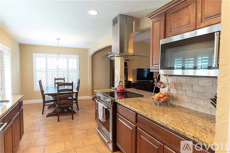 A kitchen with brown cabinets and a tile floor.
