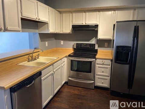 A kitchen with white cabinets and a wooden countertop.