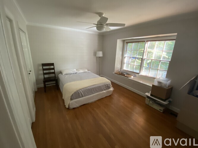 A bedroom with a bed, a window, and a ceiling fan.