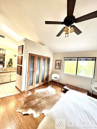 A bedroom with a cowhide rug on the floor.