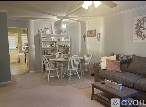 A living room with a dining table set up with chairs around it.