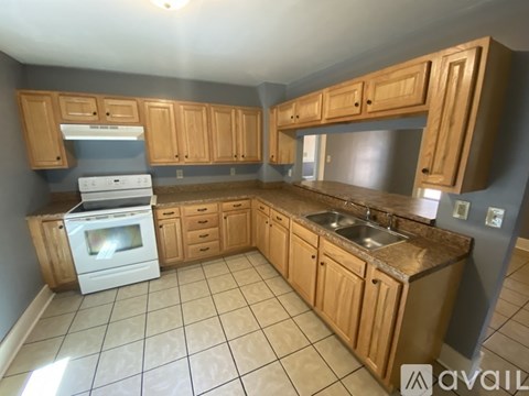 A kitchen with wooden cabinets and a white oven.